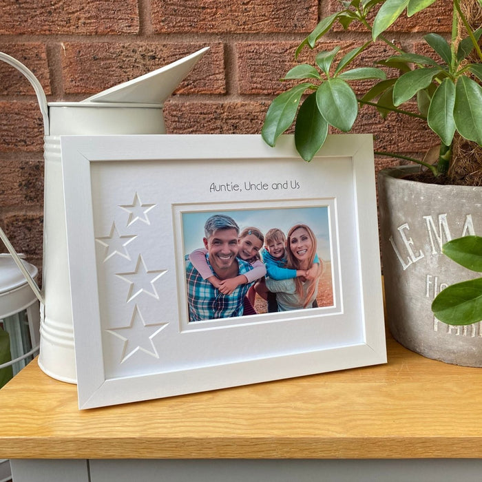 White frame on brown tabletop next to green plants and cream jug