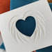 white photo mount in the shape of a heart and wings, Blue and orange cushions