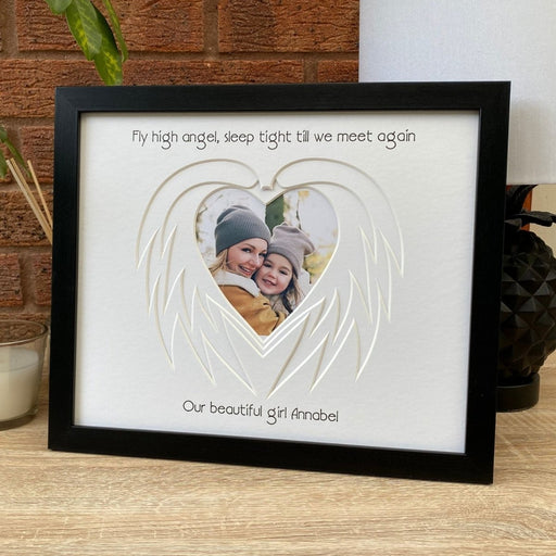 Heart Angel Wing mount in a black frame on tabletop